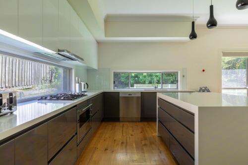 a kitchen with white counters and a stove top oven at Spacious Home with Ensuites in Mount Waverley