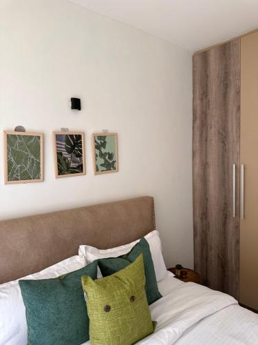 a bedroom with a bed with green and white pillows at Spacious studio Ruaka in Ruaka
