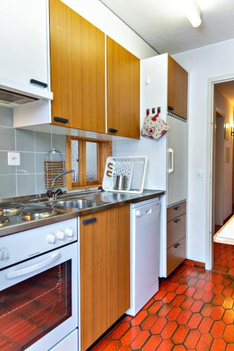 a kitchen with white appliances and wooden cabinets at Chesa Allegria - Sils Maria in Sils Maria