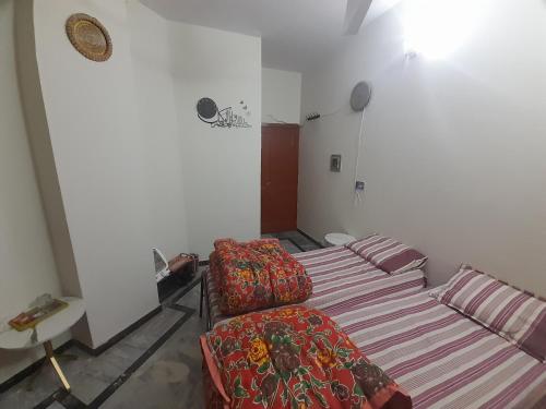 a bedroom with two beds and a couch in it at MM ROYAL suites in Islamabad