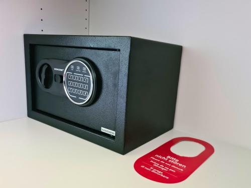 a small safe with a red remote control next to it at Zeitlos Hotel Garni in Scharbeutz