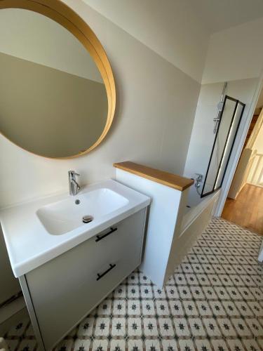 une salle de bain avec un lavabo blanc et un miroir dans l'établissement Maison Paris La Défense, à Asnières-sur-Seine