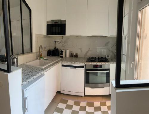 a white kitchen with a sink and a stove at Maison Paris La Défense in Asnières-sur-Seine