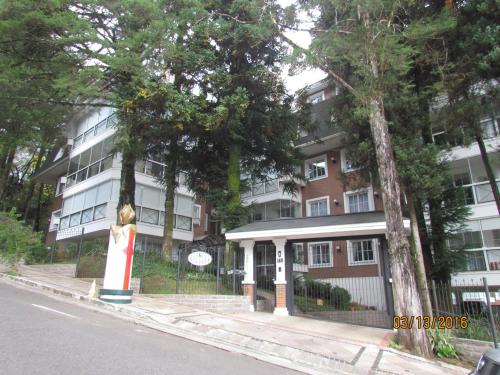 un immeuble d'appartements avec une statue en face de celui-ci dans l'établissement Apartamento Homeland 305, à Gramado