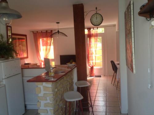 une cuisine avec un comptoir et une horloge au mur dans l'établissement Plage Parc Parking, à La Rochelle