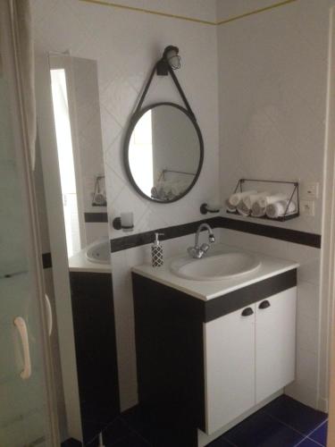 une salle de bain avec un lavabo et un miroir dans l'établissement Plage Parc Parking, à La Rochelle