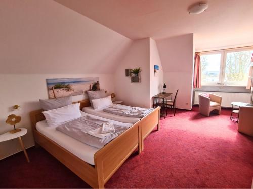 a bedroom with a bed and a red carpet at Zeitlos Hotel Garni in Scharbeutz