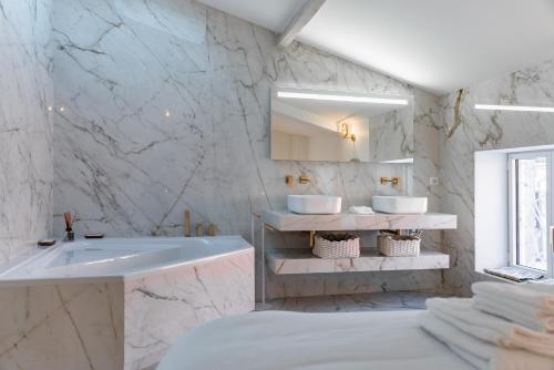 La salle de bains blanche est pourvue d'un lavabo et de deux miroirs. dans l'établissement 4 pièces sur la rue d'Antibes - Rénové et climatisé, à Cannes