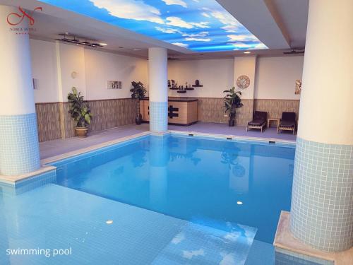 una gran piscina en un edificio con techo en Noble Hotel, en Erbil