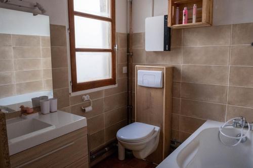 une salle de bain avec toilettes, lavabo et fenêtre dans l'établissement Cœur d 'amande, à Narbonne