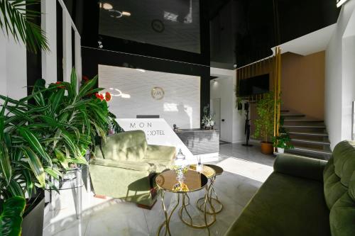a living room with a couch and a table and some plants at Mon Invite Hotel in Yerevan