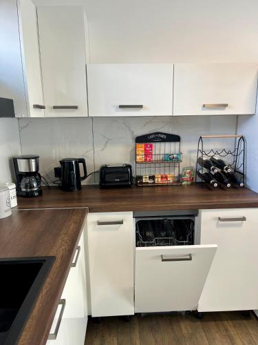 a kitchen with white cabinets and a white dishwasher at Domek Prosetin244 in Prosetín