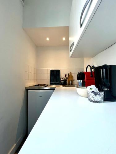 - une cuisine avec un comptoir blanc dans une pièce dans l'établissement Appartement de charme tout équipé à Paris, pour 4 personnes, 2 grands lits, à Levallois-Perret