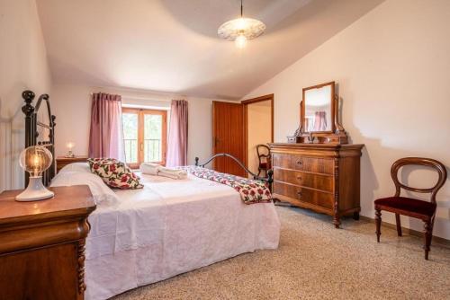una camera da letto con un letto, un comò e uno specchio di Vertine Countryside a Gaiole in Chianti