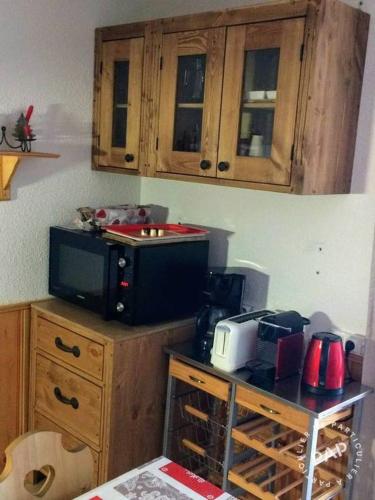 une cuisine avec un four micro-ondes au-dessus d'un comptoir dans l'établissement STUDIO - LA TRIADE - 50m remontée VAL CENIS LE HAUT, à Lanslevillard