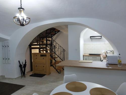a kitchen with an archway and a spiral staircase at Hanna Vendégház-Tállya in Tállya