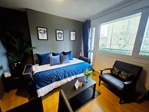 a bedroom with a bed and a chair and a window at Wellington Apartment in London