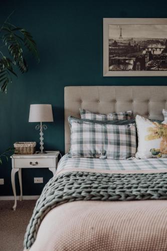 CygnetにあるGreen Gables B&B Waterfront Apartment with King Bed & Breakfast in Huon Valleyの緑の壁のベッドのある寝室