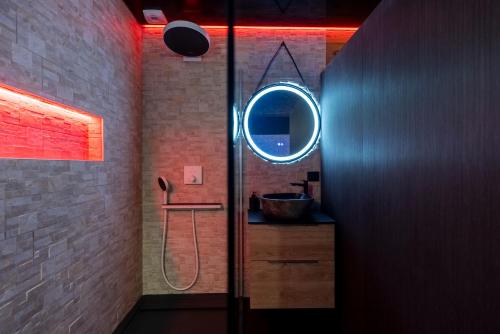 a bathroom with a shower with a sink and a mirror at Love Room Tentation in Ornans