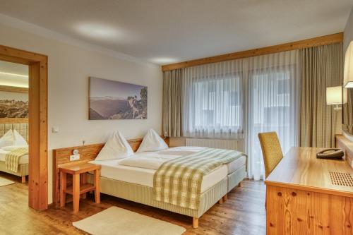 a hotel room with a bed and a desk at Hotel Alte Post in Fieberbrunn