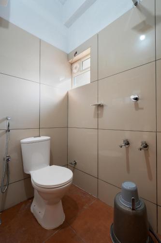 a bathroom with a toilet and a glass shower stall at Yaad Inn in Cochin