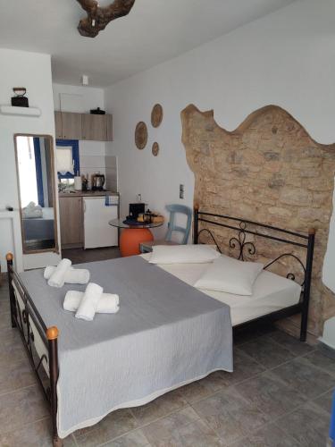 a bedroom with a large bed with towels on it at Margarita's Rooms in Chora Folegandros