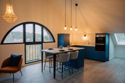 une cuisine avec une table et des chaises ainsi qu'une grande fenêtre dans l'établissement Moulin Lèves-Chartres Au fil de l eau, à Lèves