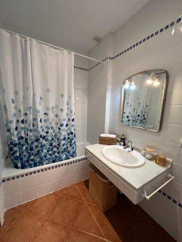 a bathroom with a sink and a shower curtain at El Paraíso de Isla Canela in Isla Canela