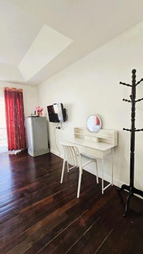 a room with a white desk and a television at Sea Boss Homestay in Kata Beach