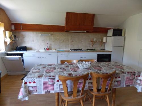 une cuisine avec une table et quatre chaises et une cuisine avec dans l'établissement Gîte Les Fremi'Zh, à Saint-Maurice-sur-Moselle