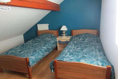 - une chambre avec 2 lits et une table de nuit dans l'établissement Gîte Les Fremi'Zh, à Saint-Maurice-sur-Moselle
