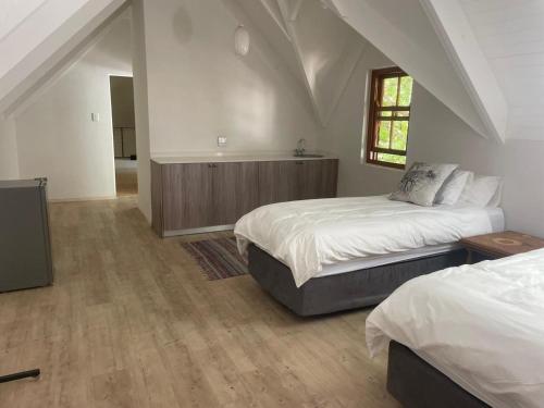 a bedroom with two beds and a window at This Is Us in Franschhoek