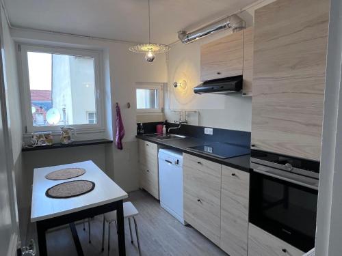 une cuisine avec un évier et une cuisinière four supérieur dans l'établissement Appartement Bulles de Lumière, à Épernay