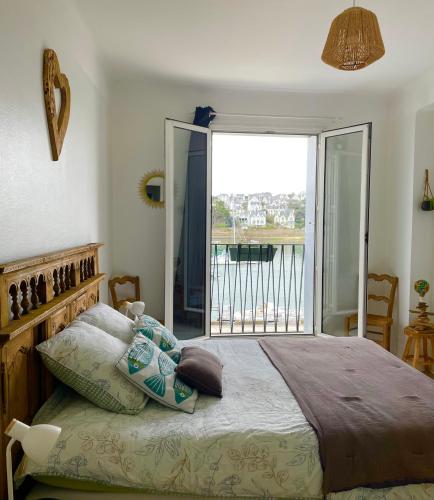 - une chambre avec un grand lit et un balcon dans l'établissement Chez Stella, à Audierne