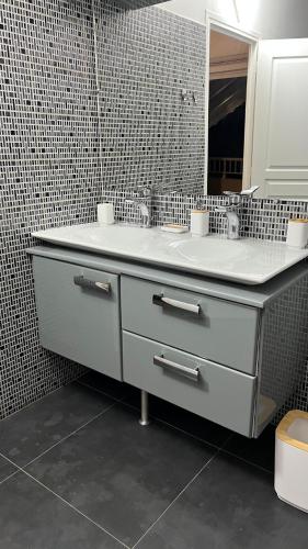a bathroom with a sink and a mirror at Secret River - Spacieuse villa de 5 chambres, 3 salle de bain, Piscine, spa avec plus de 400 ml de Rivière privée in Sainte-Rose