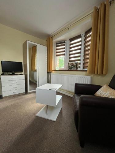 a living room with a couch and a table at Quest Fulfiller - Near General Hospital, Free Parking & Garden in Southampton