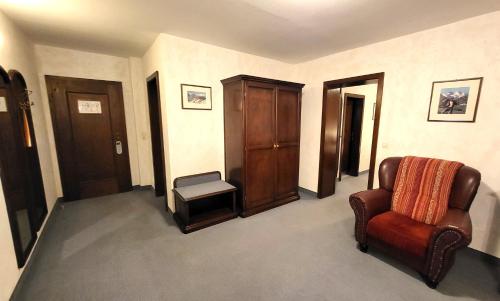 a living room with a chair and a cabinet at Hotel-Restaurant Batzenhäusl in Innsbruck