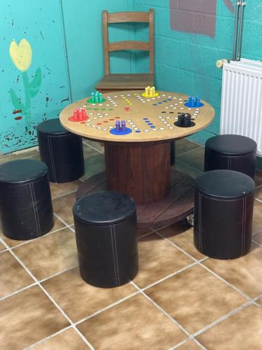 a table and stools in a room with a table and chairs at La Maison du Bonheur in Gouvy