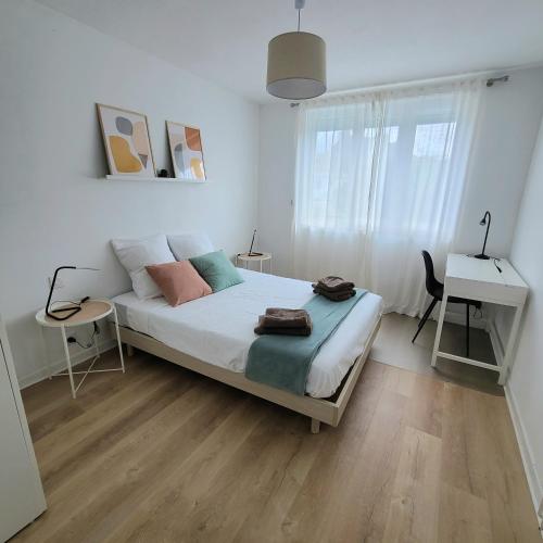 une chambre blanche avec un lit et un bureau dans l'établissement Le Gouedic - 2 chambres - 3 lits - 60m2, à Saint-Brieuc