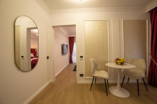 a room with a table and chairs and a mirror at Crystal Luxury in Craiova