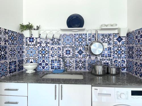 a kitchen with blue and white tiles on the wall at SeaSun in Ashqelon