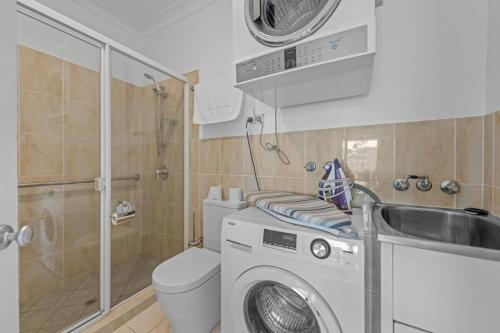 a bathroom with a washing machine and a sink at Lux Penthouse, Private Rooftop in Brisbane
