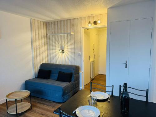 un salon avec un canapé bleu et une table dans l'établissement Studio rénové proche plage et commerces, parking, à Quiberon