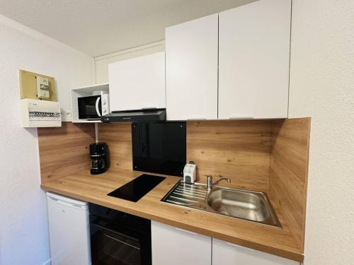 une cuisine avec un évier et un micro-ondes dans l'établissement Studio rénové proche plage et commerces, parking, à Quiberon