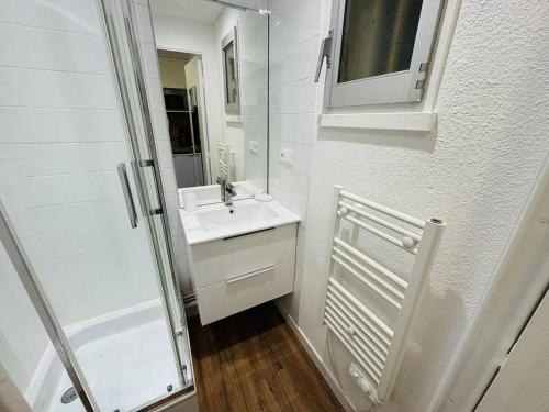 une salle de bain blanche avec un lavabo et un miroir dans l'établissement Studio rénové proche plage et commerces, parking, à Quiberon