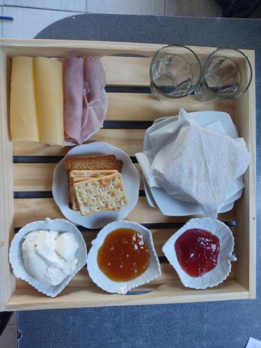 een houten blad gevuld met verschillende soorten voedsel bij La Catalpa B&B in Ciudad Lujan de Cuyo