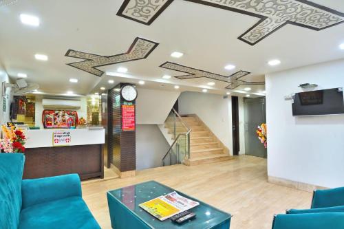a lobby with blue chairs and a clock on the ceiling at The Bella Vista -Traveler's choice awarded in New Delhi
