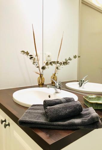 une salle de bain avec un lavabo blanc et deux miroirs dans l'établissement Appartement vue magnifique sur les Alpilles, résidence avec Piscine, à Paradou