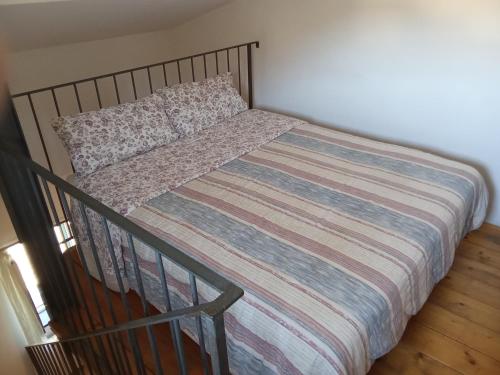 a bed with a striped comforter in a bedroom at Agriturismo Cele in Celle Ligure
