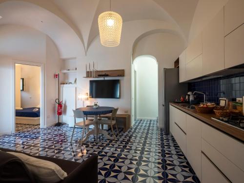 a kitchen with a table and a dining room at Villa Cliff House - Le Sea House in Atrani